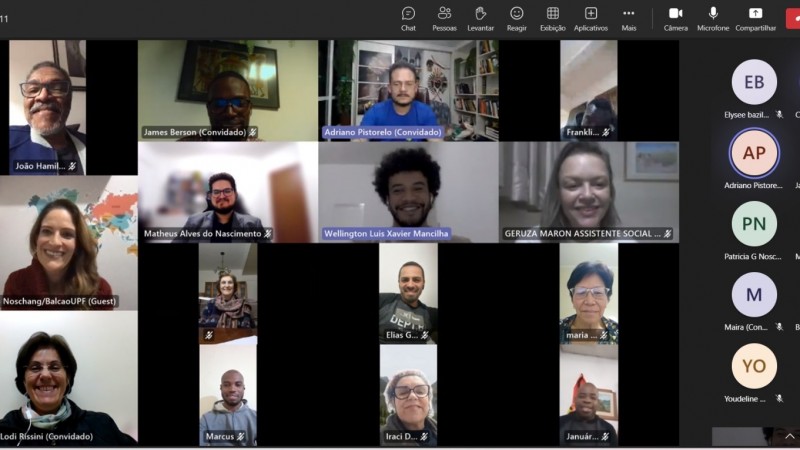 Print da reunião virtual com os rostos dos participantes. Todos estão sorrindo.