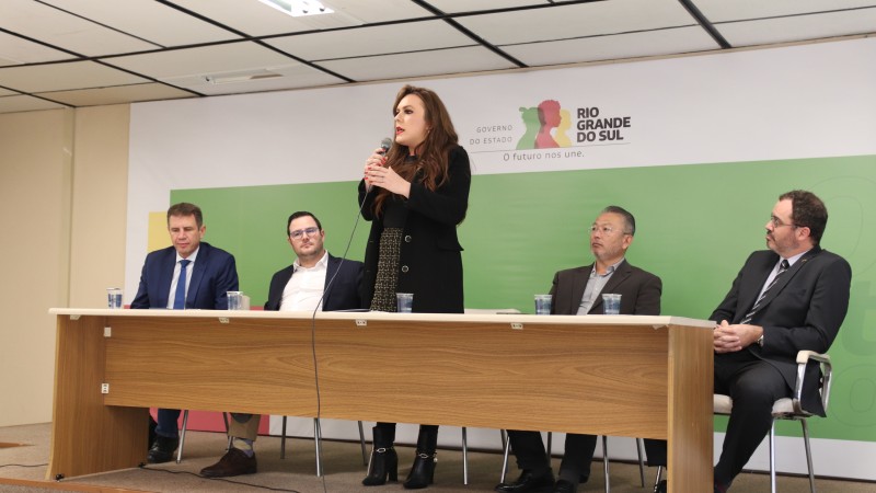 Mesa de abertura com a presença da Secretaria da Cultura em exercício, Gabriela Meindrad; do Secretario de Justiça, Cidadania e Direitos Humanos, Mateus Wesp; do Desenvolvimento Econômico, Ernani Polo e do Adjunto da Segurança Pública, Coronel Mário Ikeda. O Subsecretário da Justiça e Integridade Institucional da SJCDH e presidente da Comissão Oficial também aparece na foto.