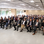 Foto do auditório mostra as pessoas sentadas e olhando para o violinista antes da apresentação.