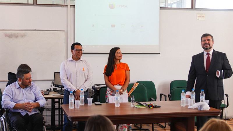 Mesa de abertura do evento, no momento de fala do Diretor Moisés, que sorridente dá as boas vindas para o público.