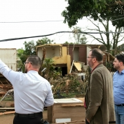 Subsecretário Rafael Gessinger e Diretor do Procon, Rainer Grigolo em Arroio do Meio observam os destroços enquanto um homem aponta para frente. 