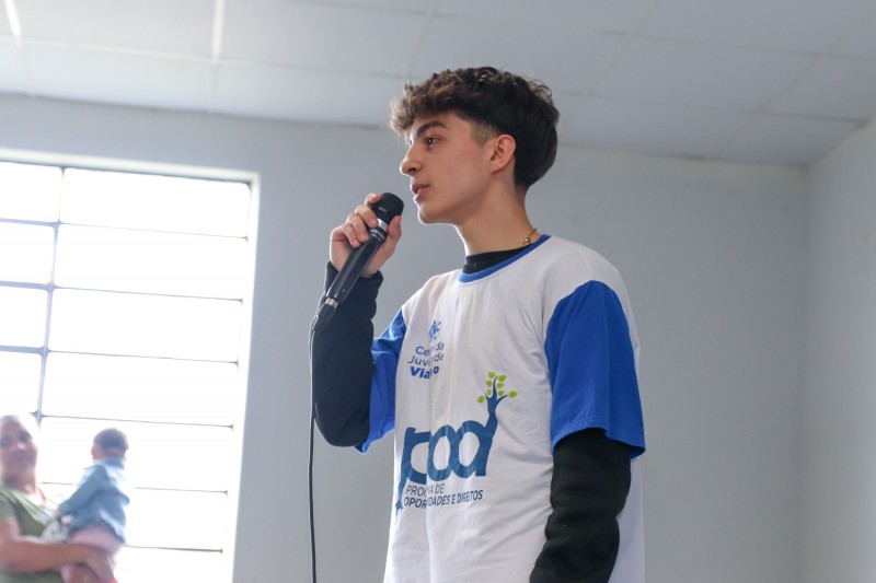 Jovem do Pod em seu momento de fala. Ele veste camiseta do Pod.