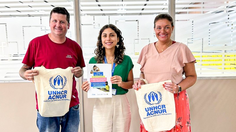 Autoridades posadas para a foto com sacola da ACNUR.