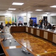 Mesa circular, com espaço vazio no meio, com os convidados sentados ao redor. 