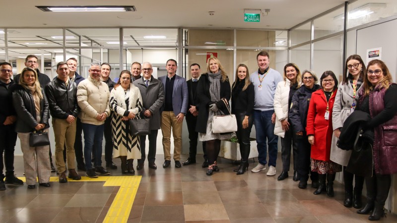 Imagem de todos os vinte representantes de poderes públicos, homens e mulheres, reunidos no corredor do 4º andar do Centro Administrativo Fernando Ferrari, lado a lado, posando para a foto.
